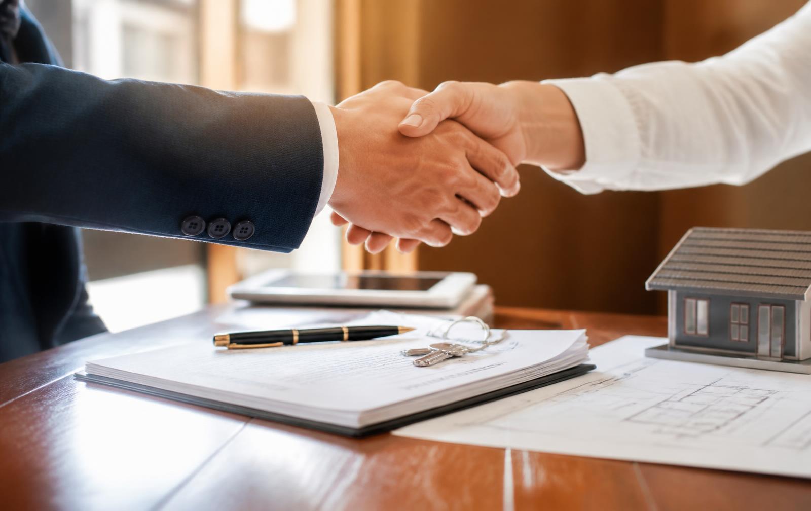 Corretor e cliente fechando negociação imobiliária